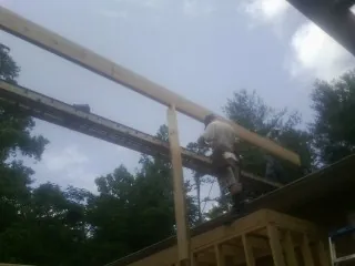 Carpenter setting a ridge beam over a new addition frame — Ice Dam Removal by Roofing Brothers in Severance