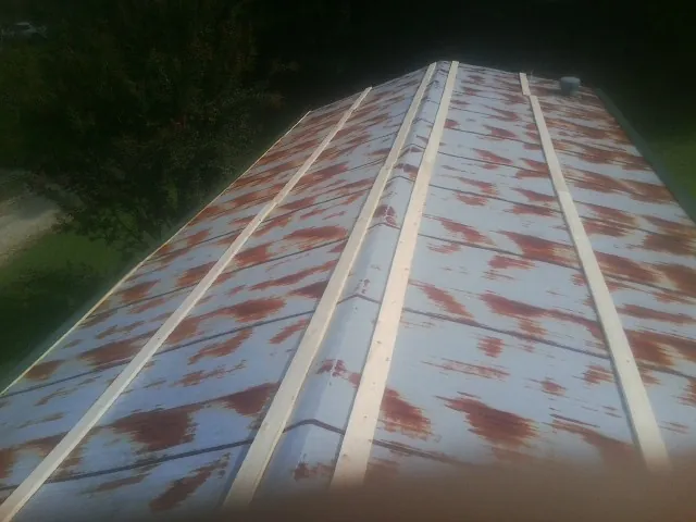 Rusted metal roof panels with new wood purlins before replacement — Storm Damage Roof Repair in Severance by Roofing Brothers