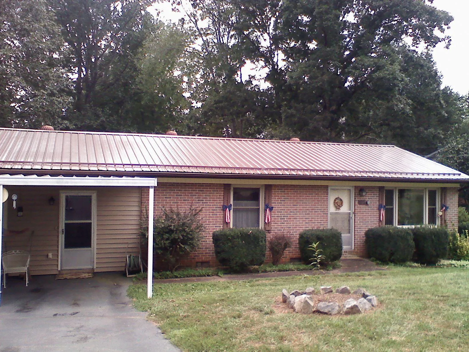 Bronze metal roof and carport on a brick ranch home — Roof Repair work by our crew in Severance